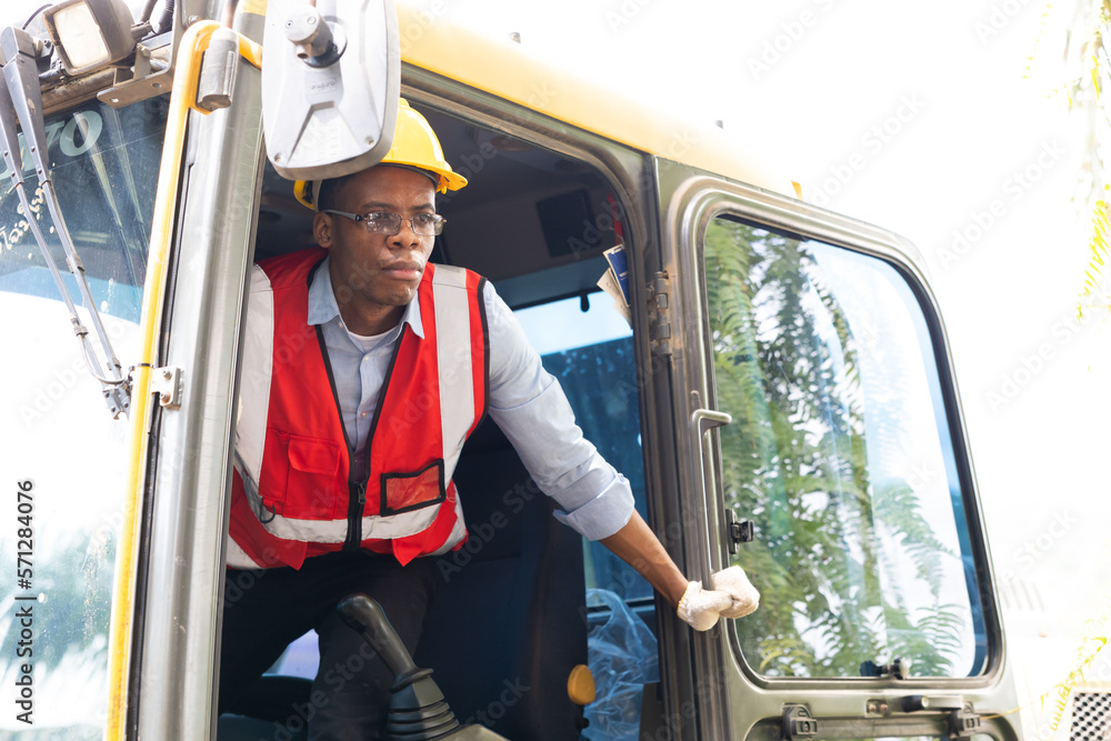 Portrait african american young Male construction worker operating on Skid tractor or construction vehicle at building site. Portrait african american young Male construction worker operating on Skid tractor or construction vehicle at building site.