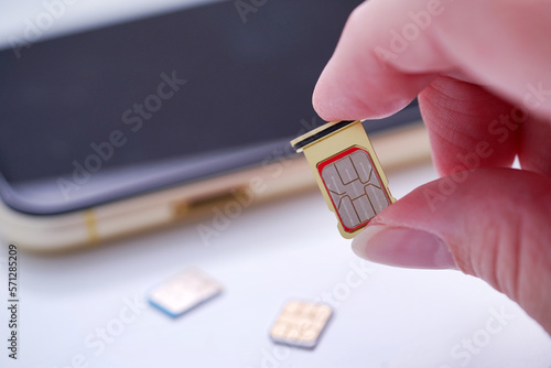 Wallpaper Mural Person inserting a sim card into back of mobile phone, Sim card in tray being inserted into phone Torontodigital.ca