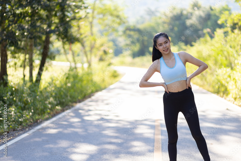 Portrait of an athlete running a woman on a street in a park. Athlete warm up the body. Portrait of an athlete running a woman on a street in a park. Athlete warm up the body.