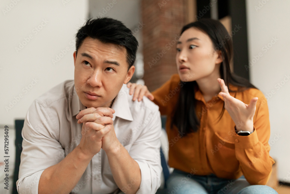Emotional chinese wife yelling and gesturing at middle aged husband, having difficulties in marriage Emotional chinese wife yelling and gesturing at middle aged husband, having difficulties in marriage