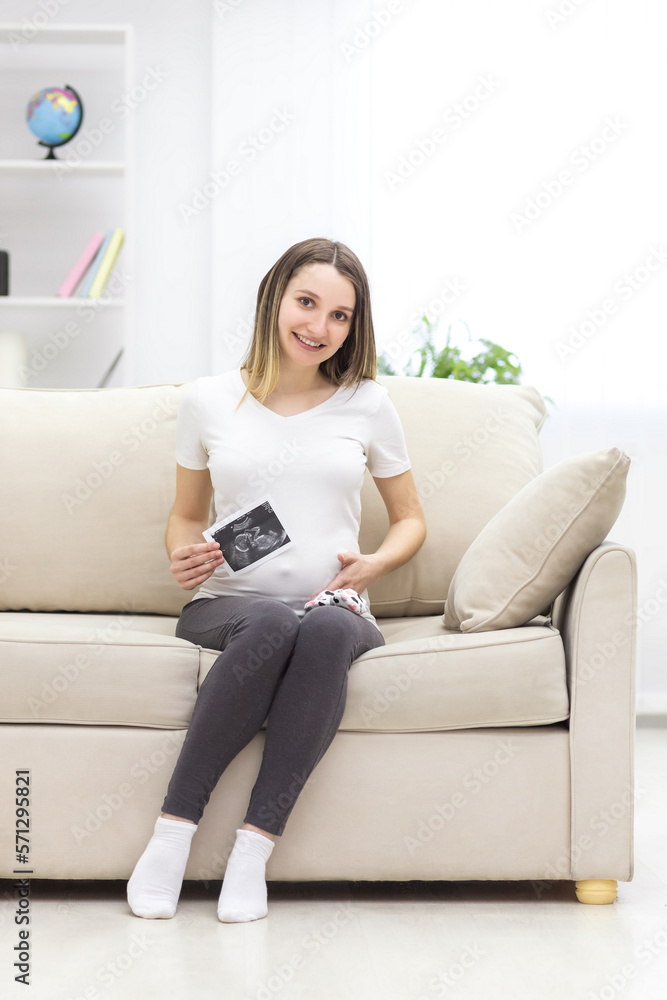 Photo of smiling pregnant woman with ultrasound result. Photo of smiling pregnant woman with ultrasound result.