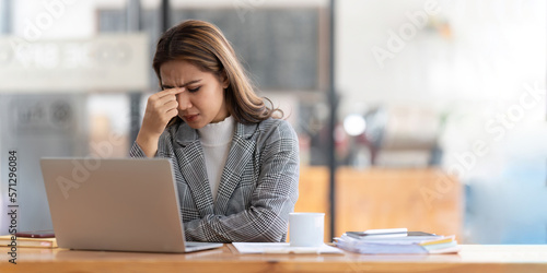 Young businesswoman working on laptop stressed has a headache and thinks hard from work at the office