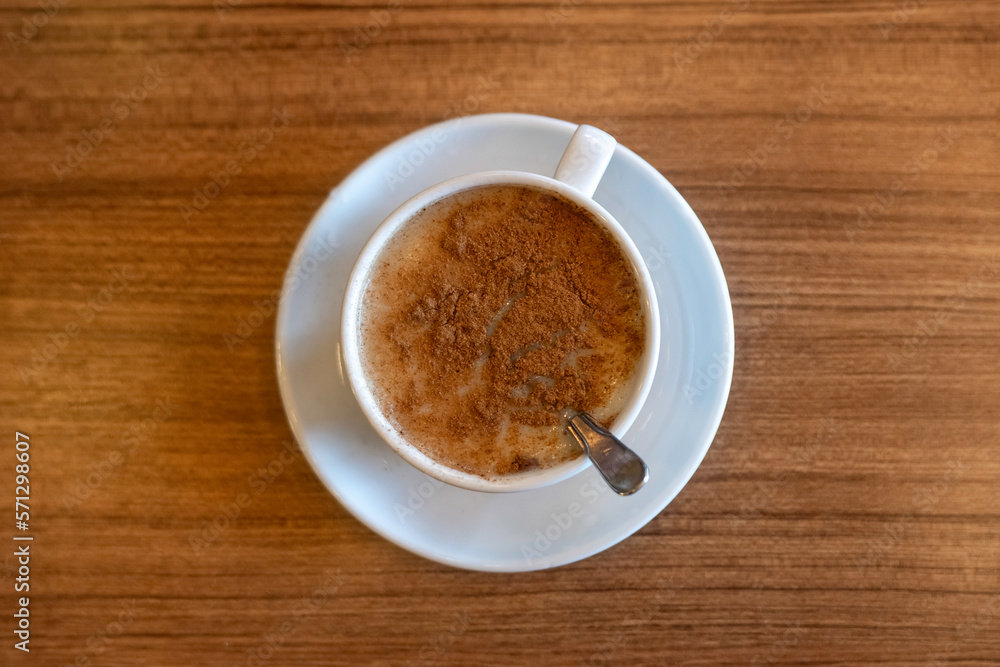 A cup of Salep on wooden table in a cafe. A cup of Salep on wooden table in a cafe.