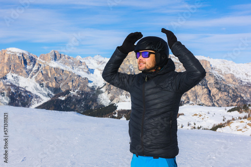 Young man, happy skier, blue sky and mountains, winter in Italy, winter sports lover, mountains in winter, landscape.