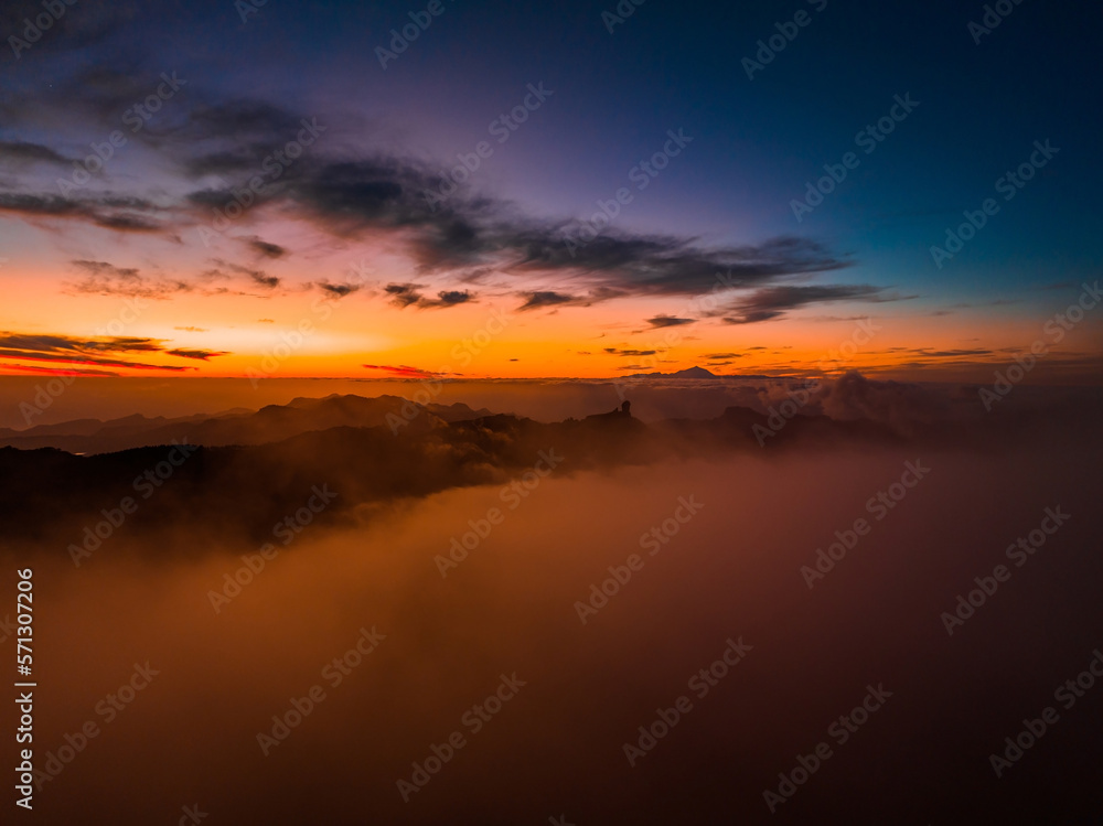 Magical sunset above the clouds with Teide volcano on the horizon. Sunset cinematic view from the top of Gran Canaria Island Pico de las Nieves point.