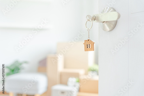 Moving house, relocation. The key was inserted into the door of the new house, inside the room was a cardboard box containing personal belongings and furniture. move in the apartment or condominium © Shisu_ka