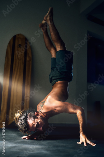Fototapeta Naklejka Na Ścianę i Meble -  mid adult man in hatha yoga pose standing upside down on hands or fingers 