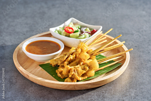 Photos thai satay skewers with grilled pork and dipping sauces served on banana leaf pl