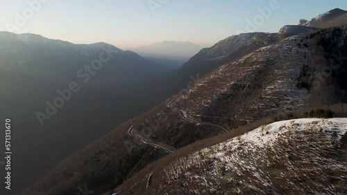 Aerial view of a scenic forest road on mountainside in wintertime at sunset with snow on Mount Terminio, Serino, Avellino, Irpinia, Campania, Italy. photo