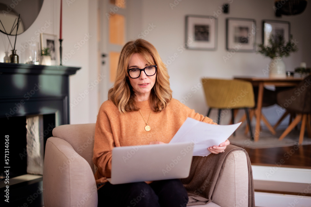 Attractive woman sitting at home and using laptop for work Attractive woman sitting at home and using laptop for work