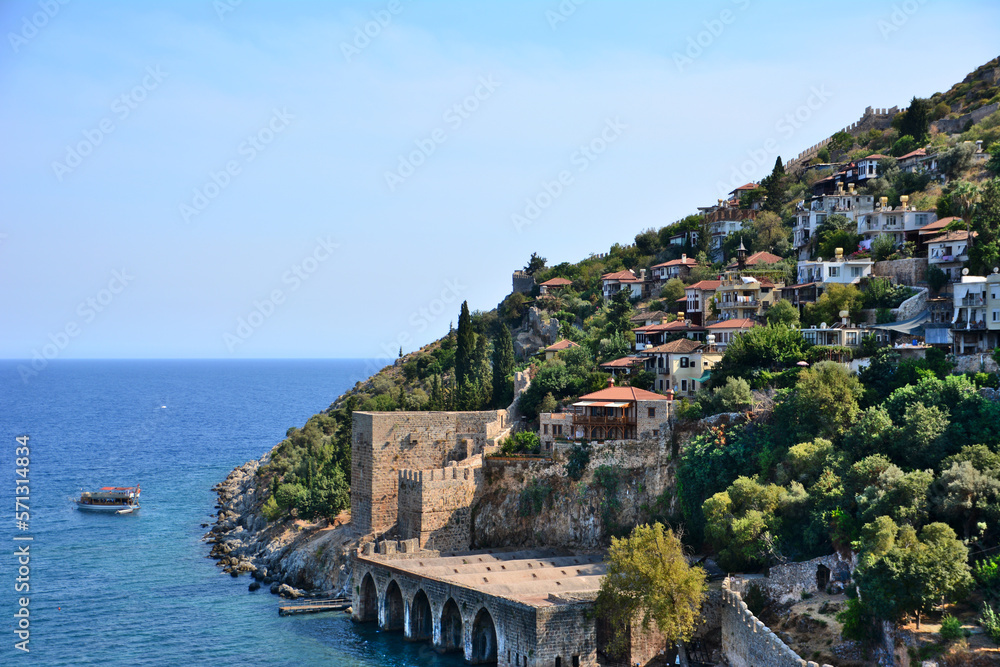 coastline with ancient fortress and residential buildings with mediterranean sea and clear sky
