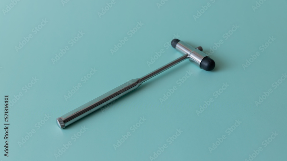 neurological hammer on a blue background. medical instrument on a turquoise background, medical equipment lies. neurological hammer on a blue background. medical instrument on a turquoise background, medical equipment lies.