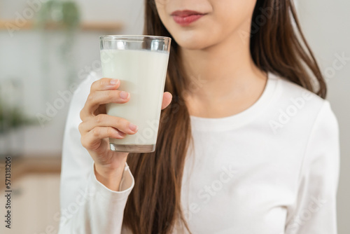 Health care, pretty asian young woman, girl drinking a glass of white fresh, dairy milk for calcium, vitamin wholesome good nutrition in morning at kitchen home. lifestyle, product healthy people.