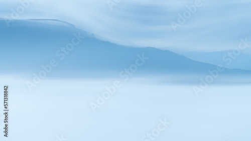 Blurred Image of Mountain Range and Clouds in Blue Tones