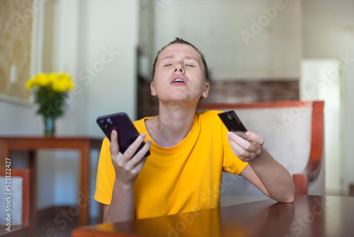 Internet fraud. Nervous sad upset unhappy confused young woman, stressed worried lady having problem with paying, buying online, shopping, stolen money, payments with credit blocked bank card