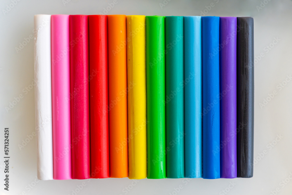 Multicolored pieces of plasticine are arranged vertically as a background. Multicolored pieces of plasticine are arranged vertically as a background.