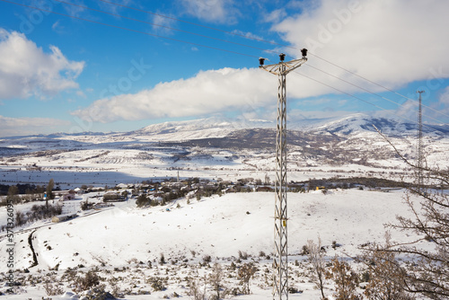 snowy mountains landscape and rows of electricity poles © Mehmet