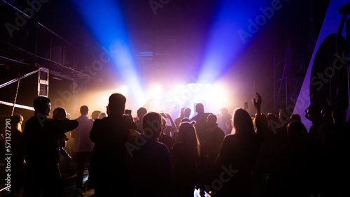 MOSCOW, Russia - February 2, 2023:Crowd dancing on a techno rave, streaming bright lights in a nightclub, cheerful vibe © Tkachenko Alexey