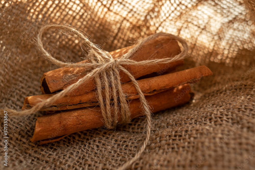 A bunch of cinnamon sticks and anise stars on burlap. Dried flowers and pieces of bark A bunch of cinnamon sticks and anise stars on burlap. Dried flowers and pieces of bark