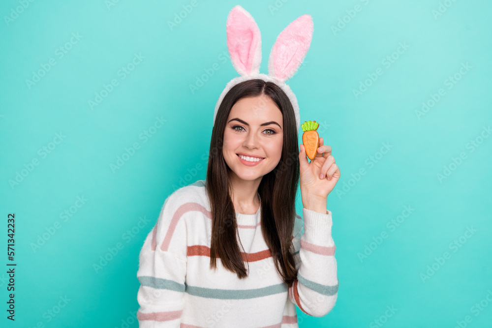 Photo of cheerful sweet woman wear striped sweater bunny headband holding biscuit isolated turquoise color background