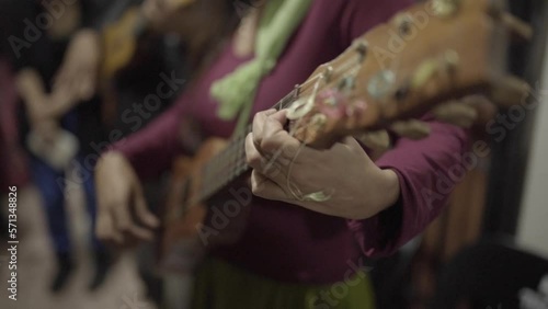 A mexican woman musician playing jarana guitar in a traditional music jam session