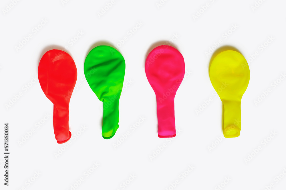 Multicolored uninflated balloons on a white background. Balloons for decoration for the holidays in a deflated state. Four air latex balloons. Set of rubber balloons Multicolored uninflated balloons on a white background. Balloons for decoration for the holidays in a deflated state. Four air latex balloons. Set of rubber balloons