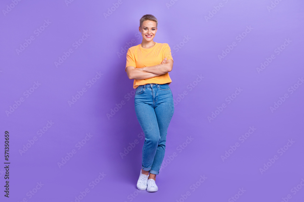 Full size photo of satisfied adorable girl dressed sneakers denim pants standing hands crossed isolated on purple color background Full size photo of satisfied adorable girl dressed sneakers denim pants standing hands crossed isolated on purple color background