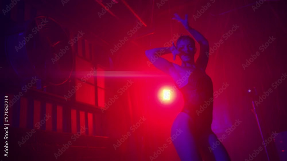 Wet girl performs contemporary dance under water rain on scene in