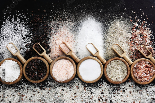 Colorful mix of salt varieties: sea and black, table and pink, himalayan and celtic. Food ingredients on dark background