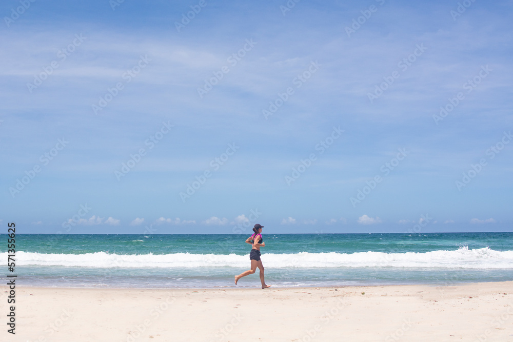 FLORIANOPOLIS, BRAZIL - JANUARY 22, 2023 : a girl runs along the beach Barra da lagoa, Florianopolis, Brazil FLORIANOPOLIS, BRAZIL - JANUARY 22, 2023 : a girl runs along the beach Barra da lagoa, Florianopolis, Brazil