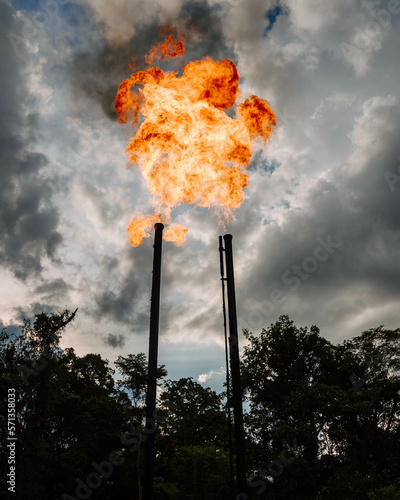Two factory funnels burning with a large flame and spewing out a thick cloud of smoke and gas.
Pollution from oil companies in the Amazon.