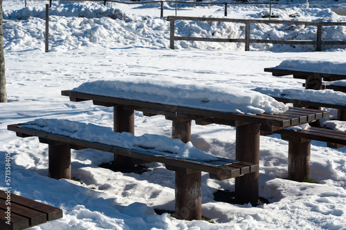 Park bench and table with lots of snow