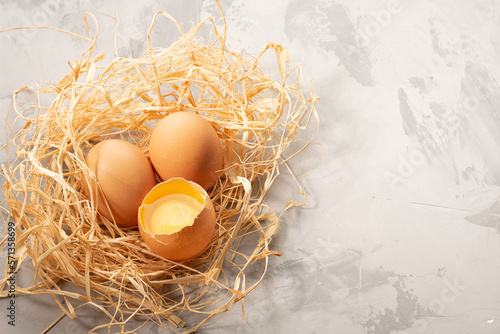 Brown eggs lay in brown paper that is made like a bird's nest. White background. High quality photo