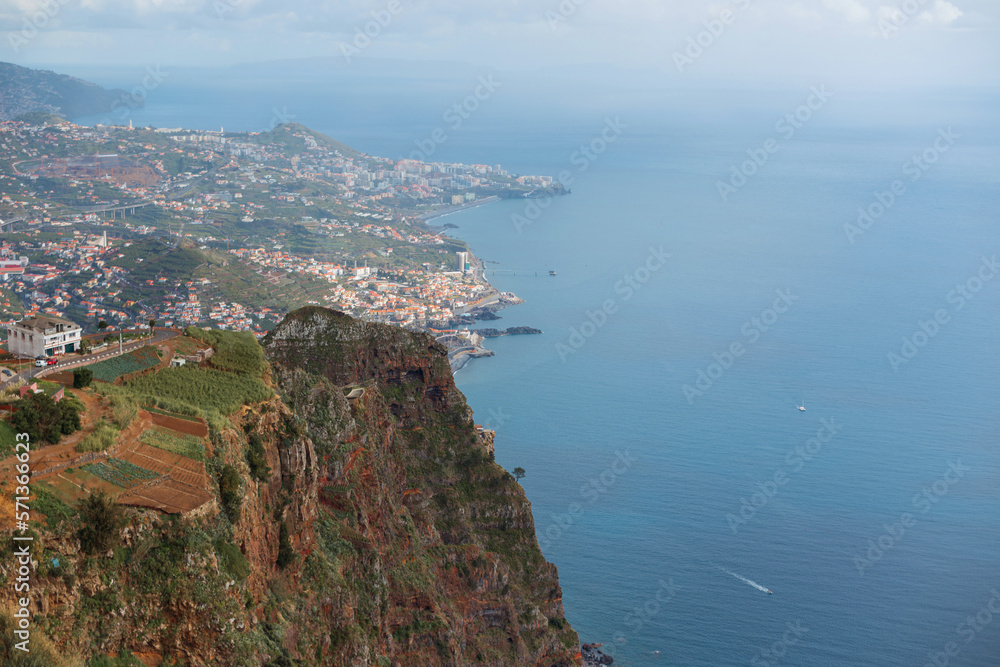 Amazing landscape with the mountains, city of Funchal, ocean and the yacht, view from above. Cabo Girao, Madeira. View from the highest cliff of Europe towards Funchal