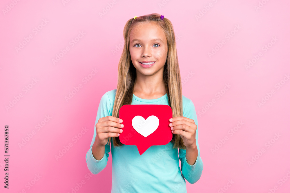 Portrait photo of preteen schoolkid girl toothy smile hold red paper like symbol positive nice cute girlish isolated on bright pink color background Portrait photo of preteen schoolkid girl toothy smile hold red paper like symbol positive nice cute girlish isolated on bright pink color background