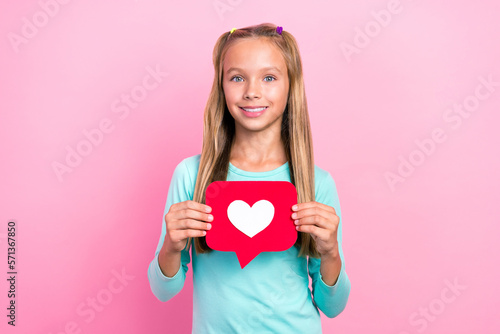 Portrait photo of preteen schoolkid girl toothy smile hold red paper like symbol positive nice cute girlish isolated on bright pink color background
