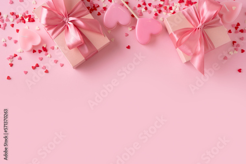 Candy pink lollipops with red gift box on pink background