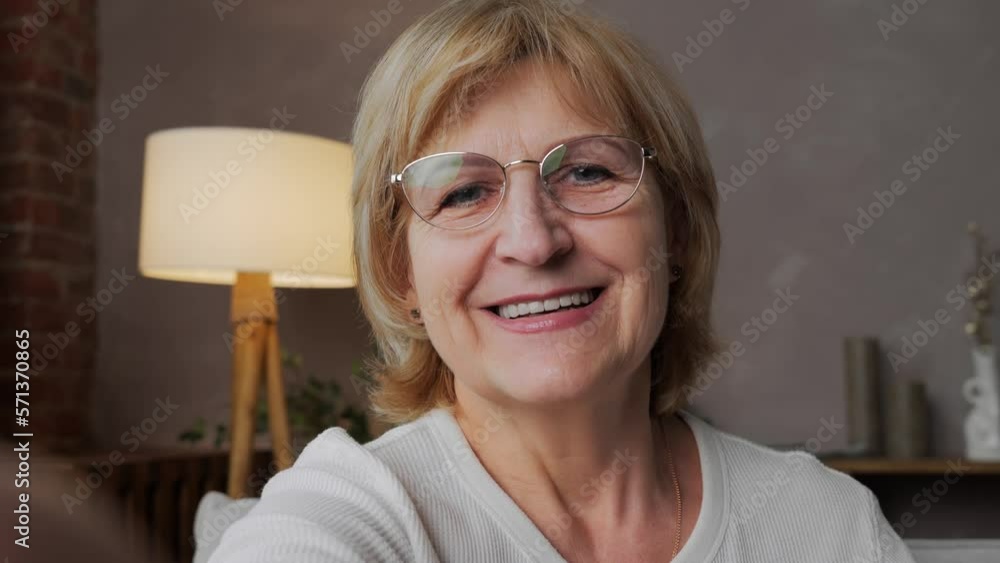 Video Stock An adult beautiful 60yearold woman is talking on a video