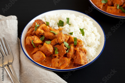 Homemade Easy Indian Butter Chicken with Rice on a Plate on a black background, side view.