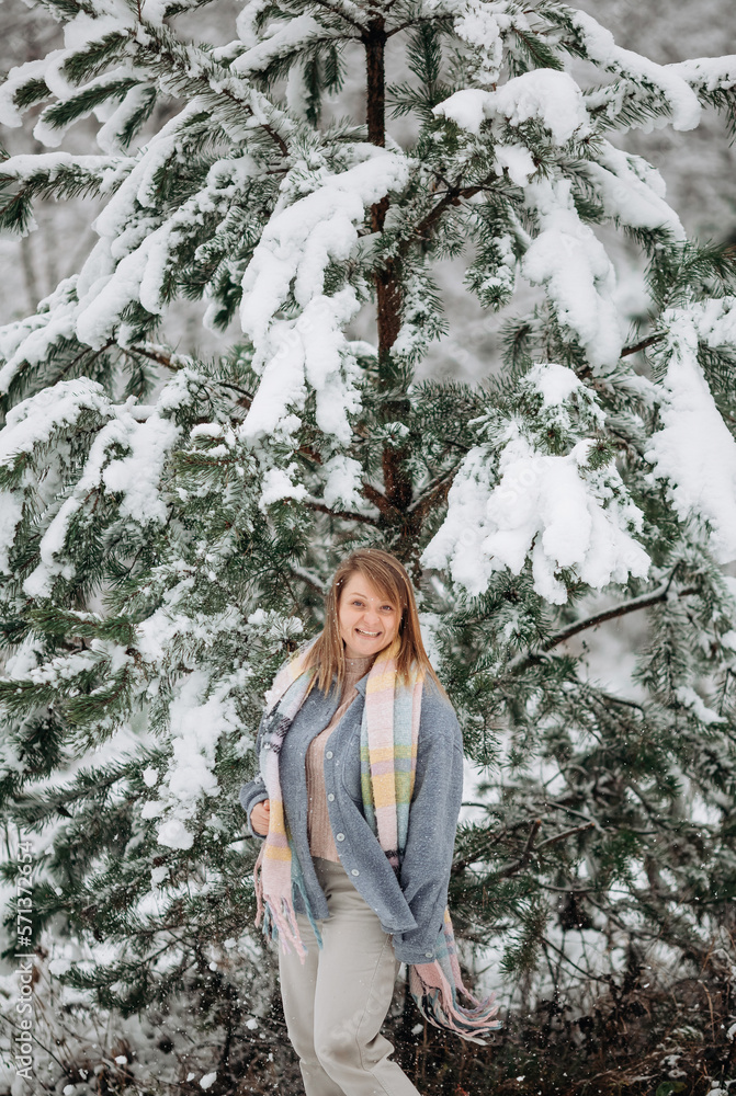 A beautiful young girl with a colorful scarf in the middle of a snowy forest A beautiful young girl with a colorful scarf in the middle of a snowy forest