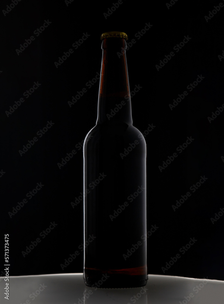 A bottle of beer on a black background A bottle of beer on a black background