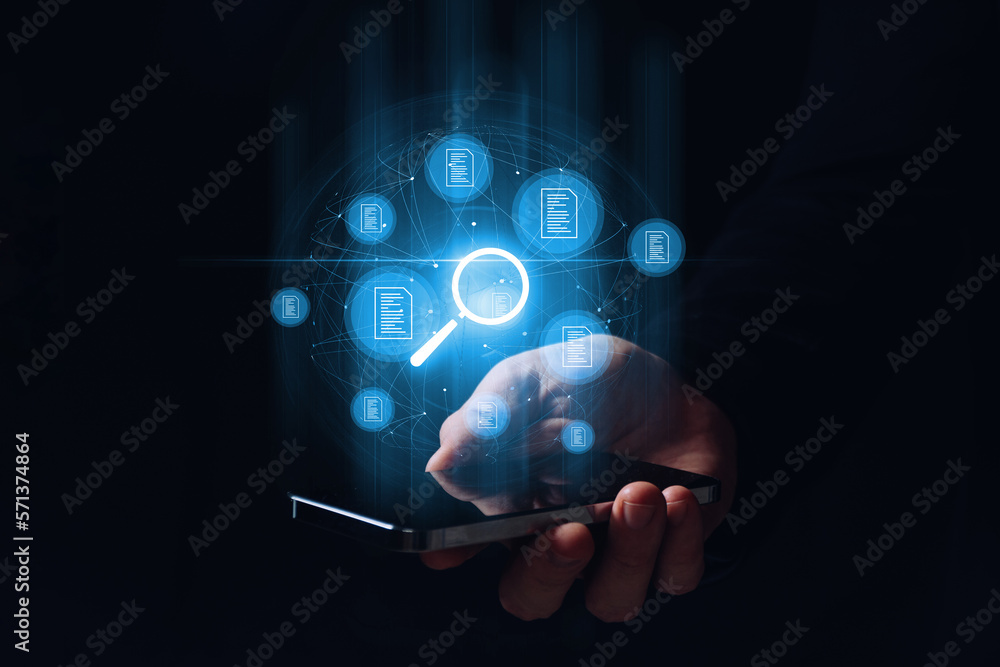Fototapeta premium A person holding a smartphone leads the search and verification of electronic documents. Hologram graphics.