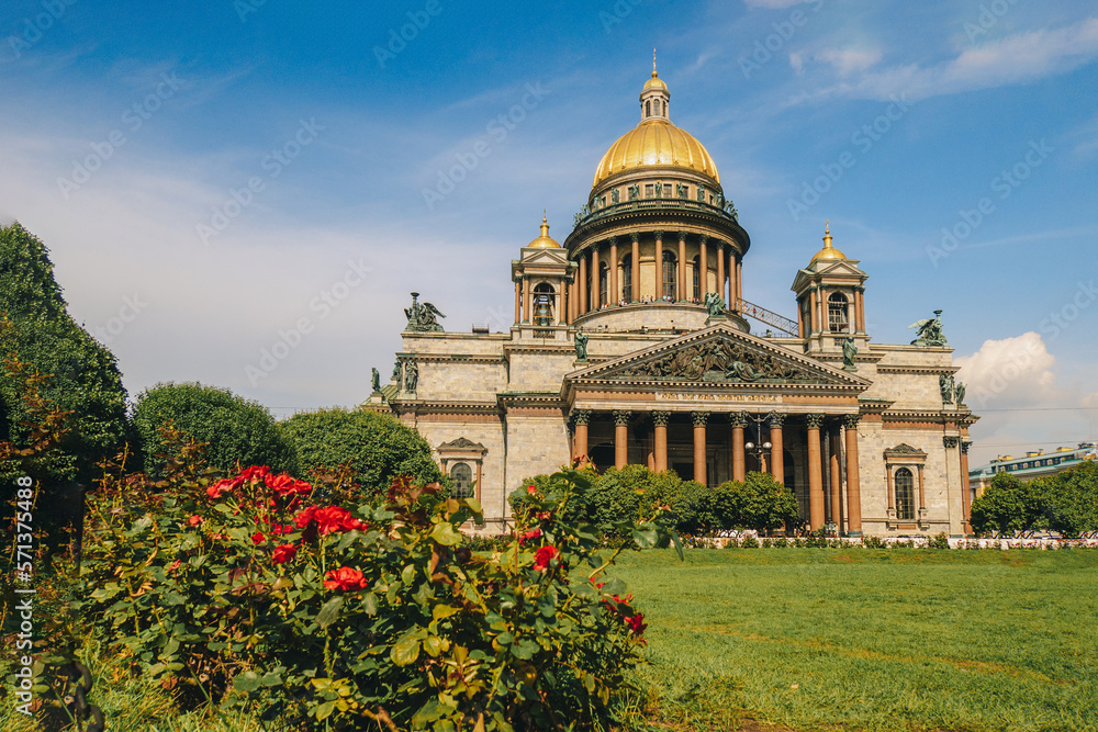 Fototapeta premium Panoramic view on Saint Isaac's Cathedral. Isaakievskiy Sobor with green lawn and red roses in summer, St. Petersburg, Russia. High quality photo