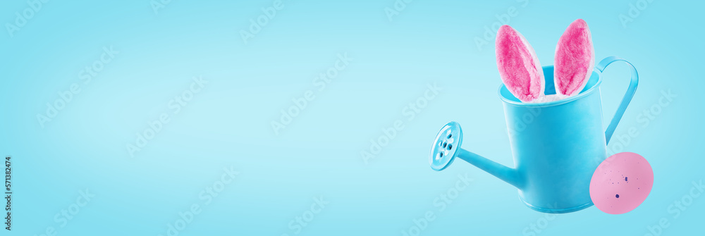 Blue Easter background with watering can, bunny ears and blue egg Blue Easter background with watering can, bunny ears and blue egg