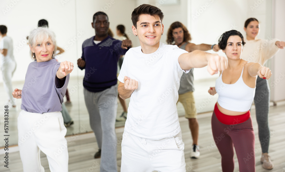 Adults people engaged in a dance studio in a group class practice sports dancing