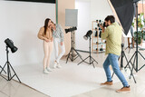 Male photographer taking picture of beautiful models in studio