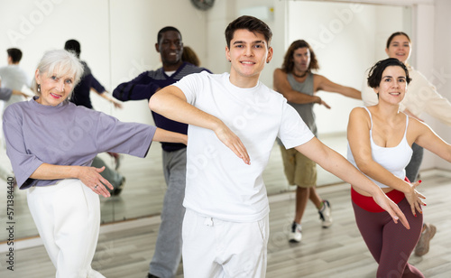 Caucasian man rehearsing modern dance with group in dance school