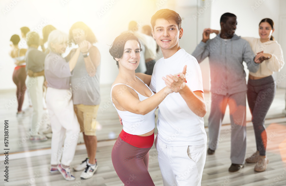 Caucasian man and young woman learning paired latin dances
