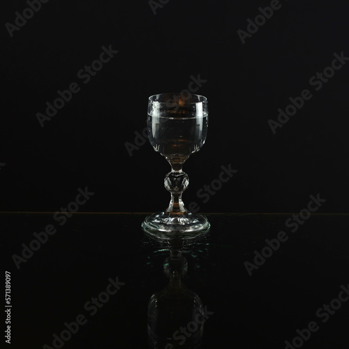 Glass on a black background. Vodka glass. A transparent glass for water or vodka. Glass cup