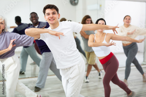 Group of active people engaged in a dance studio practicing energetic swing during lesson